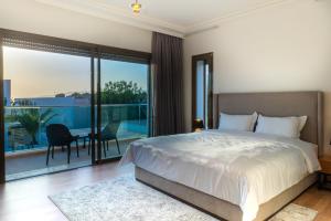 1 dormitorio con 1 cama grande y balcón en Houd Taghazout - luxury villa - Pool - 6 or 7 Px, en Taghazout