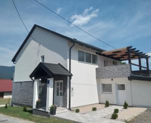 una casa blanca con techo negro en Rooms Vanteo, en Korenica