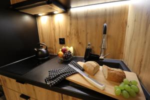 una tabla de cortar con pan y uvas en un mostrador de cocina en Sander Apartments, en Cracovia