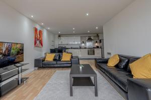 a living room with a black leather couch and a table at Amazing Views - 2 Bed - Parking - Central Bham in Birmingham
