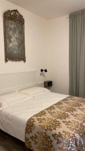 a bedroom with a bed and a mirror on the wall at Bilocale Carrara Centro con giardino e parcheggio moto in Carrara