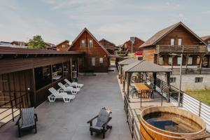 an outdoor deck with a hot tub and tables and chairs at Suzanne Băile Figa- camere tip hotel in Beclean