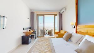 a hotel room with a bed and a living room at Acrotel Elea Beach in Elia