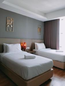 a hotel room with two beds and a window at Townhouse OAK 591 Shah Alam By Salaam Suites in Shah Alam