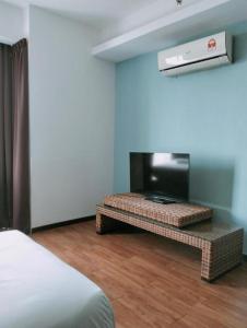 a room with a bed and a table with a television at Townhouse OAK 591 Shah Alam By Salaam Suites in Shah Alam
