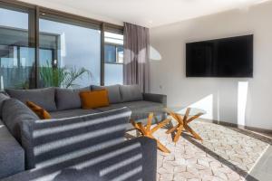 un soggiorno con divano e TV di Salam Taghazout - luxury villa - Pool - 8 Px a Taghazout