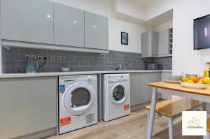 a kitchen with two washing machines and a table at Monthly Offers, 10 Guests, Business, WIFI in Derby