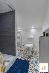 a bathroom with a white toilet and a blue rug at Monthly Offers, 10 Guests, Business, WIFI in Derby