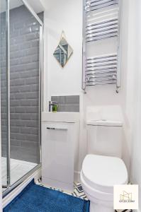 uma casa de banho branca com um WC e um chuveiro em Monthly Offers, 10 Guests, Business, WIFI em Derby
