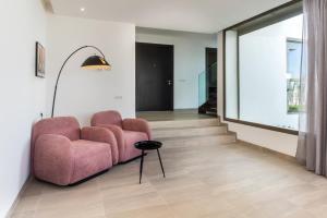 een woonkamer met een roze stoel en een lamp bij Salam Taghazout - luxury villa - Pool - 8 Px in Taghazout