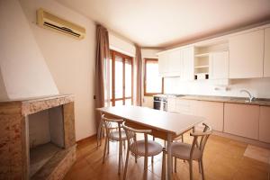 cocina con mesa, sillas y chimenea en Pulli's Home - Comfy&Cozy House, en Selargius