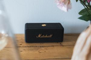 une boîte noire assise sur une table en bois avec un vase dans l'établissement Studio - Centre La Salle les Alpes Serre Chevalier, à La Salle Les Alpes