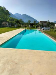 una piscina azul con montañas en el fondo en Guesthouse il Ciliegio, en Sorbo Serpico