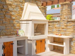 a kitchen with an outdoor oven in a patio at Salinea Apartments in Sečovlje