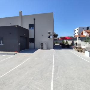 a parking lot in front of a white building at Apartments Anamarija in Zadar