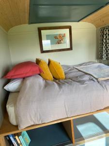 una cama con almohadas coloridas en una habitación en Renison's Farm en Penrith