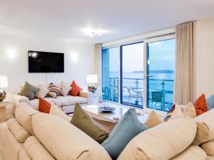 a living room with a large couch and a large window at Riva - sea views in Poole