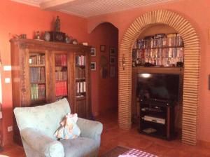 ein Wohnzimmer mit einem Sofa und einem TV in der Unterkunft Villa climatisée, piscine in Jeresa