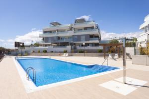 una piscina frente a un gran edificio en Home2Book Stylish & Relax Attic La Tejita, Pool en La Tejita