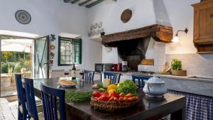 een keuken met een tafel met groenten en fruit erop bij MULINO NEL CHIANTI 10, Emma Villas in Gaiole in Chianti