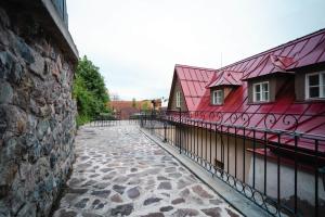 um edifício vermelho com uma cerca ao lado de um passeio de pedra em HoStel Cosmopolitan* em Banská Štiavnica