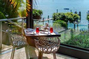 HERMITAGE Lake Lucerne - Beach Club & Lifestyle Hotel في لوتزيرن: طاولة وكراسي مطلة على المحيط