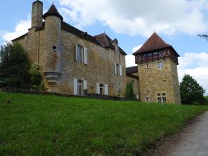 ein altes Backsteingebäude mit einem Turm auf einem Hügel in der Unterkunft Château à Gourdon dans le Lot in Gourdon-en-quercy