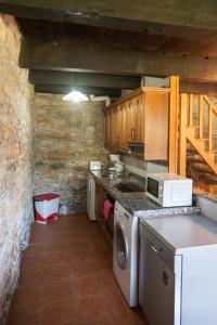 a kitchen with a stove and a washing machine at Casa Rural Pandelo in Vega de Valcarce