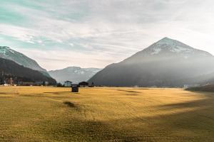 a field with a mountain in the background with snow at Purest in Achenkirch