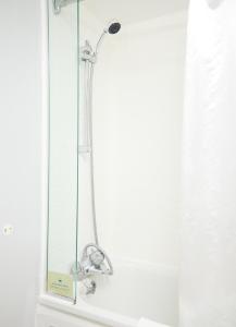 een douche met een douchekop in de badkamer bij White Hart Hotel by Greene King Inns in Braintree