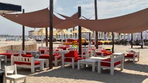 a group of chairs and tables on a beach at La malul marii in Mamaia Nord