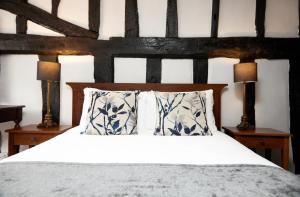 a bedroom with a bed with two night stands and two lamps at White Hart Hotel by Greene King Inns in Braintree