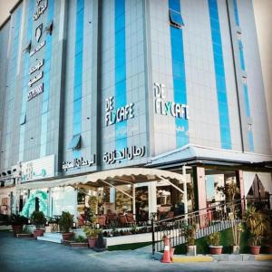 a large building with plants in front of it at رمال الجزيره in Al Ḩawīyah