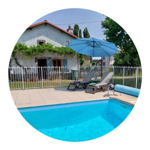 a pool with two chairs and an umbrella at B&B Franglaise in Romagne