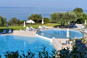 a large swimming pool with chairs and umbrellas at Acrotel Elea Beach in Elia