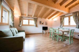 a living room with a couch and a table and chairs at Chalet Elena in Livigno