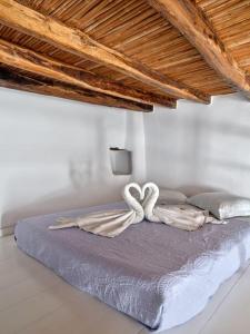 a bed in a room with two white towels on it at Lindo House in Lefkes