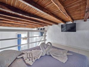 a bedroom with a bed with a tv on a wall at Lindo House in Lefkes