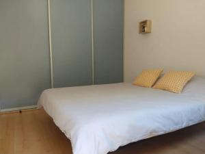 ein Schlafzimmer mit einem weißen Bett mit zwei Kissen in der Unterkunft Vakantiehuis Hoog Noordwijk in Noordwijkerhout