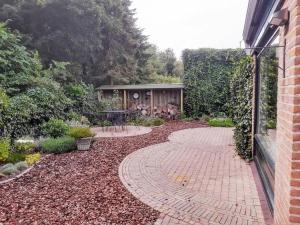 einen Garten mit einem Backsteinsteg neben einem Gebäude in der Unterkunft Vakantiehuis Hoog Noordwijk in Noordwijkerhout