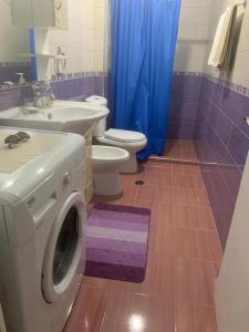 a bathroom with a washing machine and a toilet at Very nice and romantic apartment in Pogradec