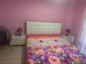 1 dormitorio con 1 cama con colcha de flores en Very nice and romantic apartment, en Pogradec