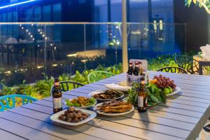 einen Tisch mit Teller mit Speisen und Flaschen Bier in der Unterkunft The Emerald Golf View in Thuan An