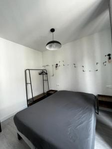a bedroom with a bed and a white wall at APP202 Proche Disneyland Lagny sur Marne in Lagny
