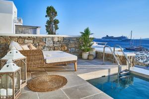 un patio con sofá y piscina en Aqua Mykonos Suites - Adults Only, en Tourlos