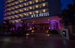 a myx hotel is lit up at night at NYX Hotel Ibiza by Leonardo Hotels-Adults Only in San Antonio Bay