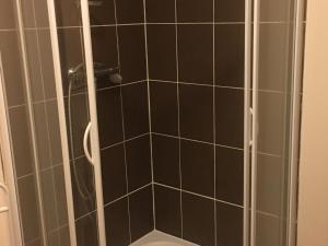 uma casa de banho com um chuveiro com azulejos pretos em Gîte Harbouey, 4 pièces, 6 personnes - FR-1-584-36 