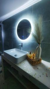 a bathroom with a white sink and a mirror at Cosy Retro Apartment in Zakynthos Town