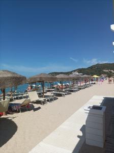 a beach with chairs and umbrellas and people on it at Vacanze a Solanas.....con Clima in Solanas