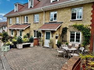 uma casa de tijolos com um pátio com uma mesa e cadeiras em Chestnut Cottage, Shanklin Rural Retreat em Shanklin